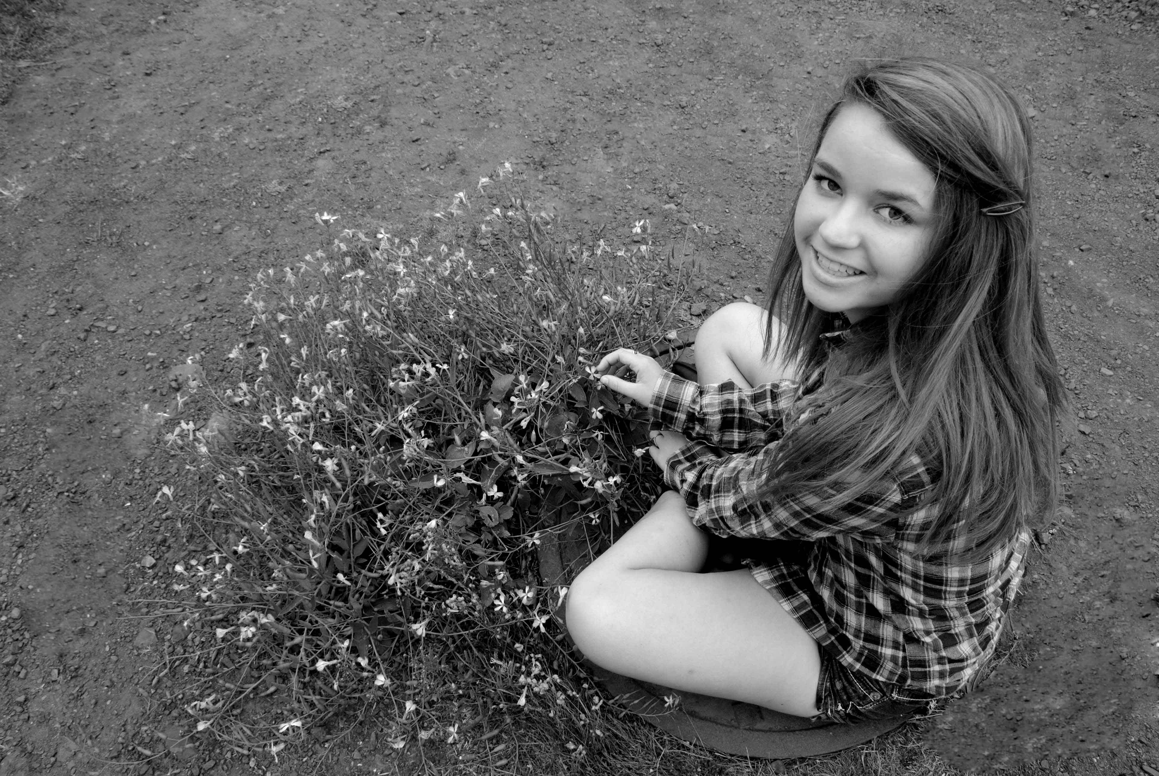 Black and white girl playing with flower bush. 