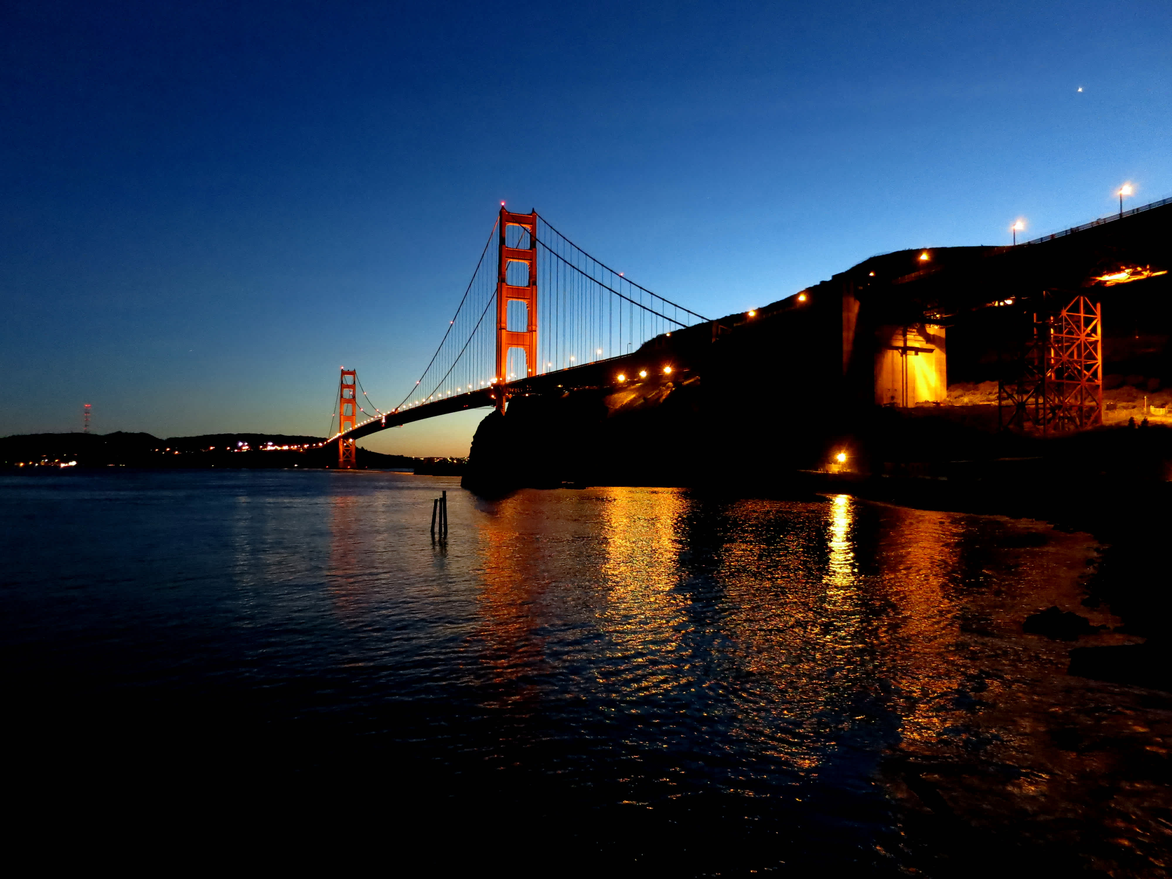 Golden Gate Bridge and nearby city in the sunset in Golden Gate Bridge, San Francisco, California.