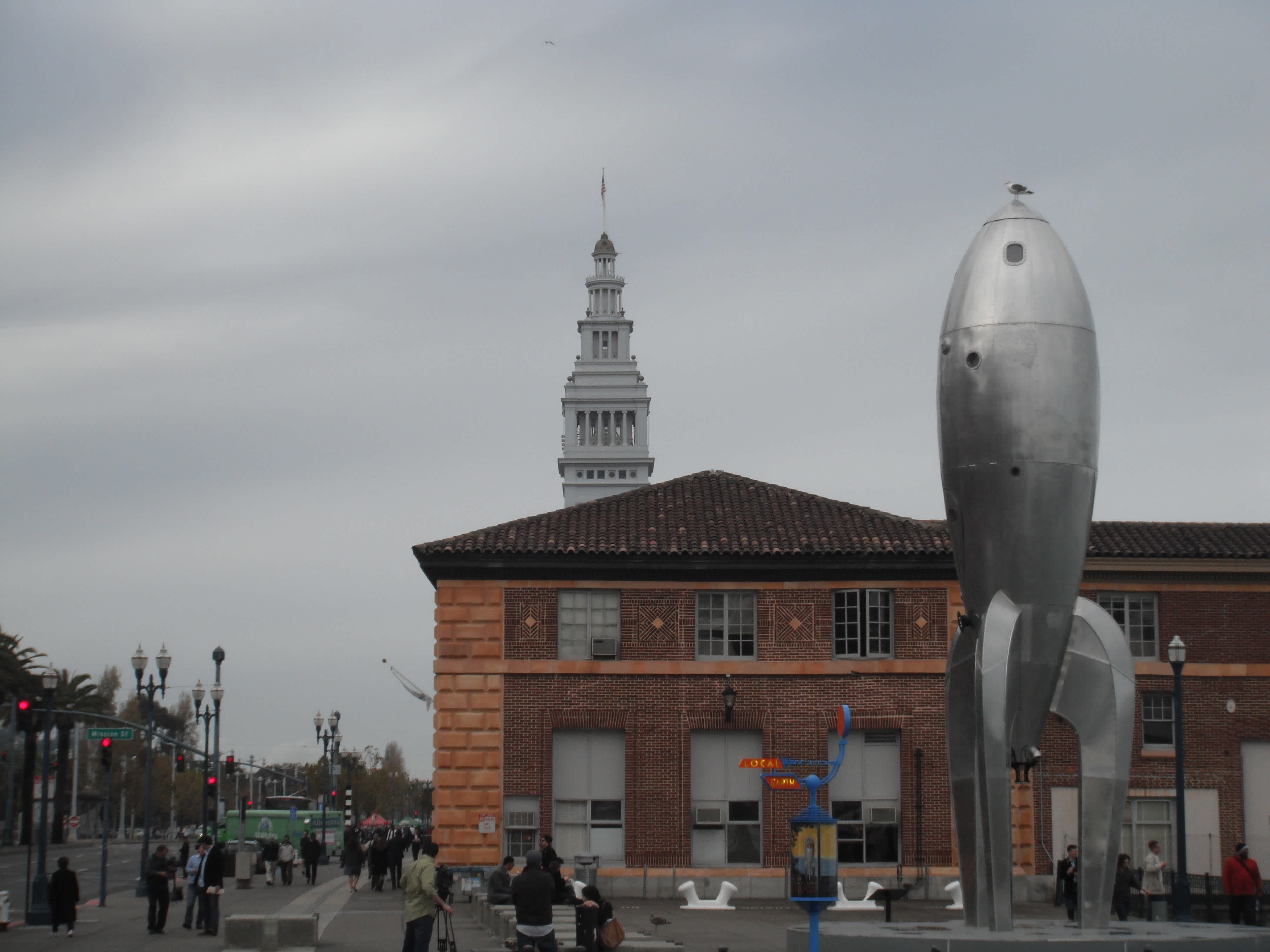 Brick building with metallic rocket ship statue in front at Ferry Building, San Francisco, California. 