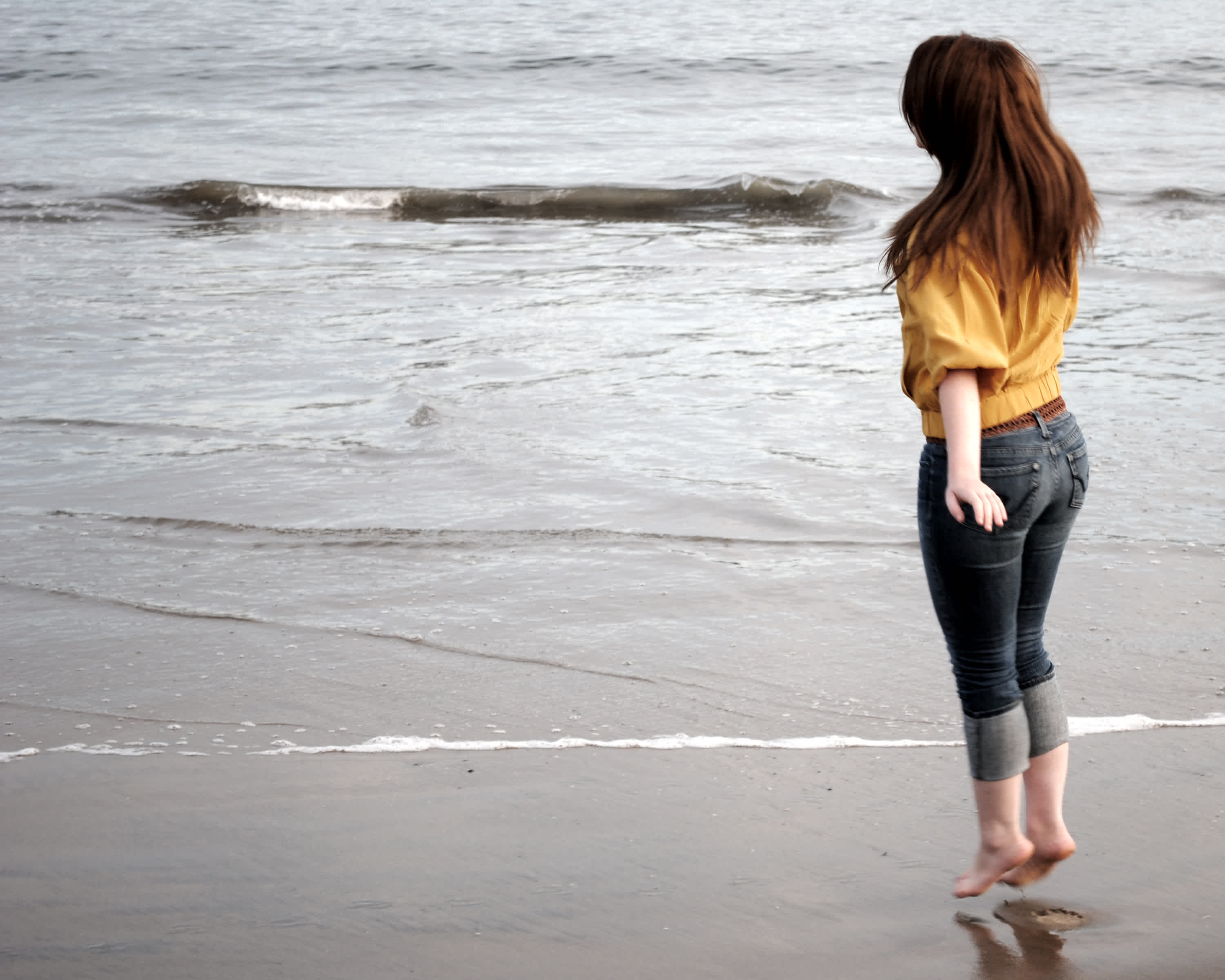 Girl on the beach overlooking the ocean. 
