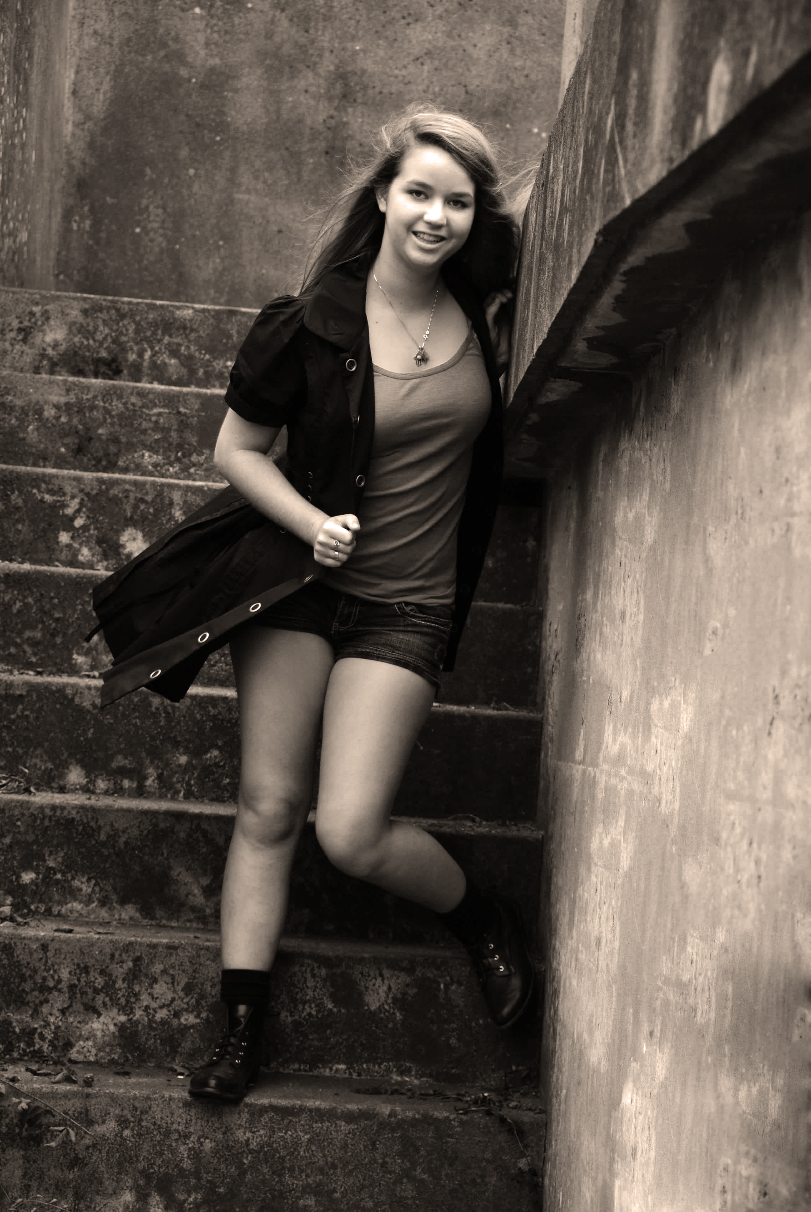 Black and white girl standing in front of a stairwell. 