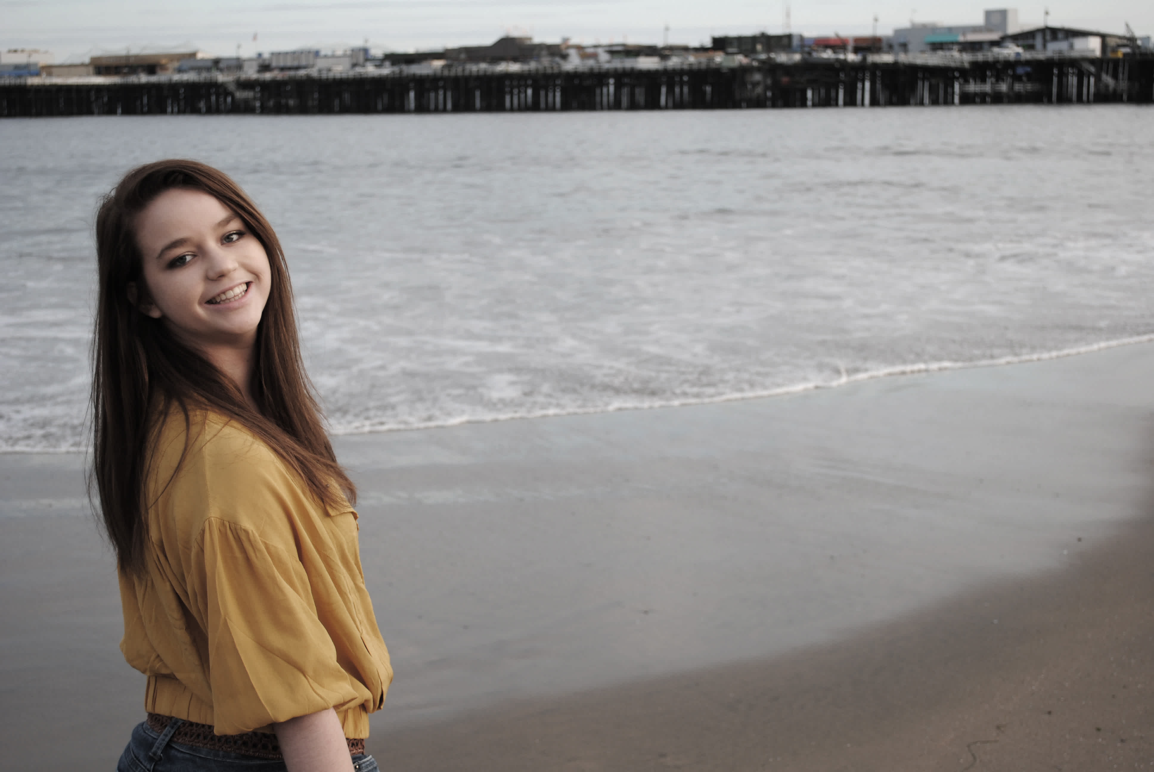 Girl in front of ocean and pier. 