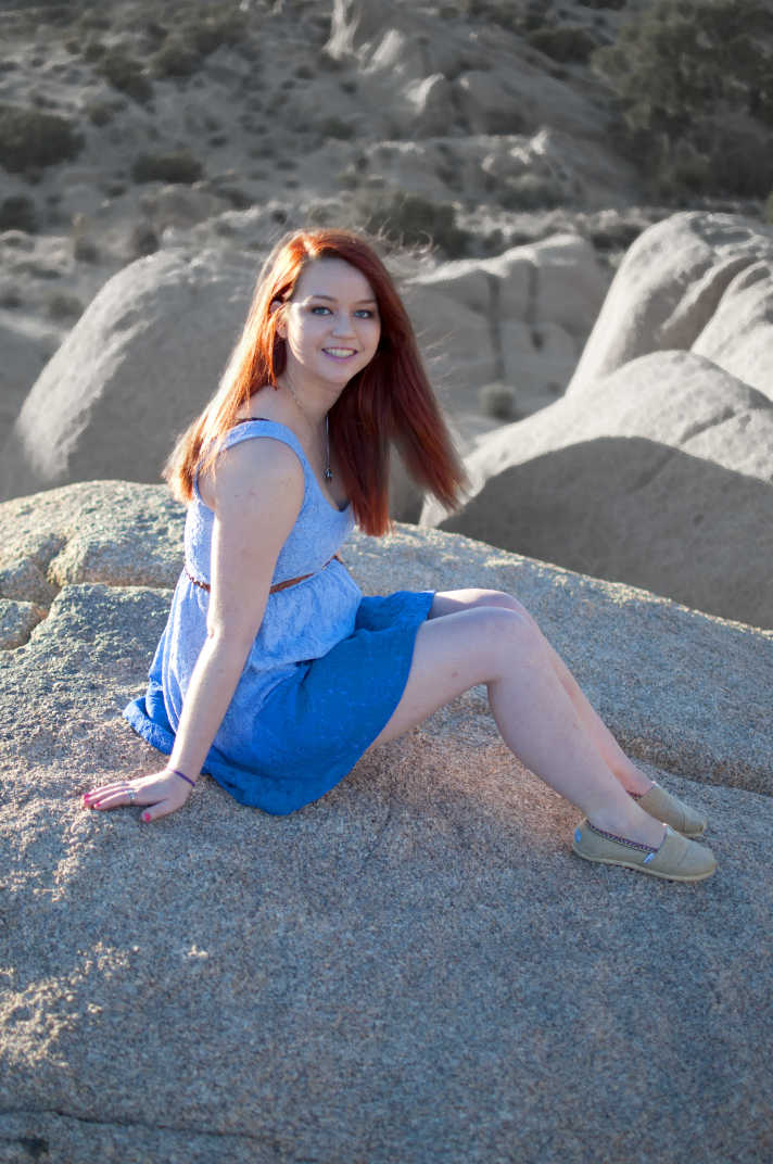 Girl sitting on a boulder. 