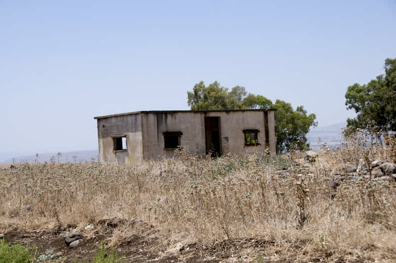 Abandoned small building in a brown field near the Jilabun Stream in Golan Heights, Israel. 
