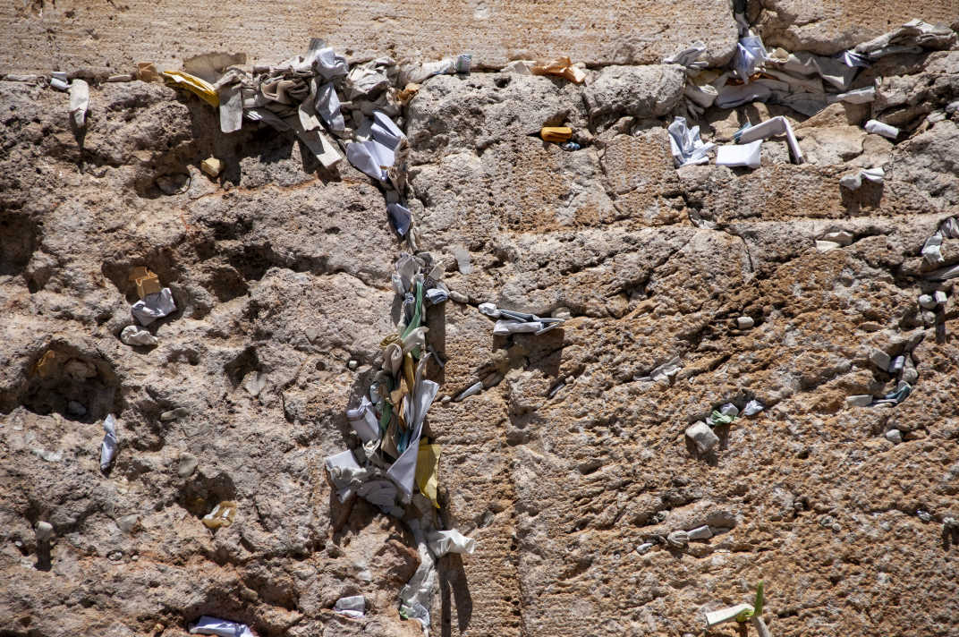 Pieces of paper containing prayers stuffed into cracks in between bricks in the Western Wall in Jerusalem, Israel