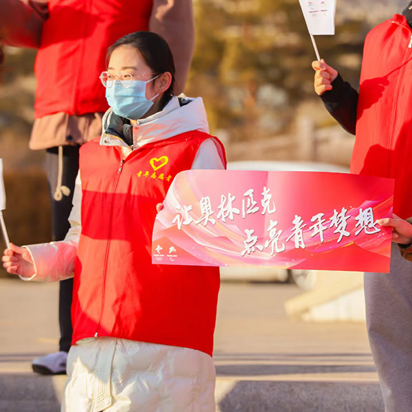先鋒計劃同學在社區組織”魅力冬奧“知識傳播行動,手舉”讓奧林匹克點亮青年夢想”手幅
