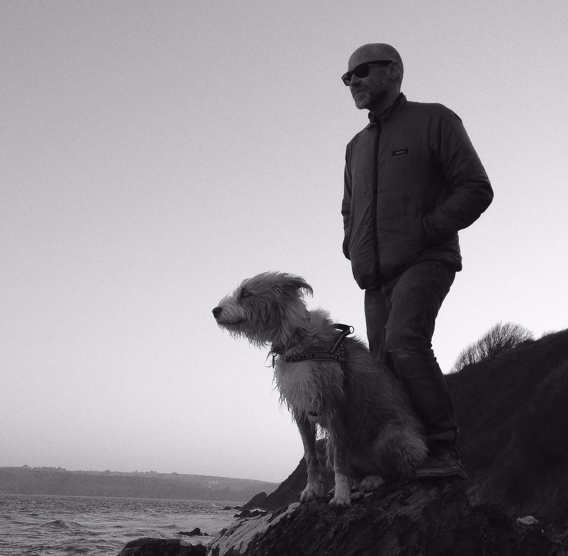 rich hardy and bryher the dog on a beach in black and white