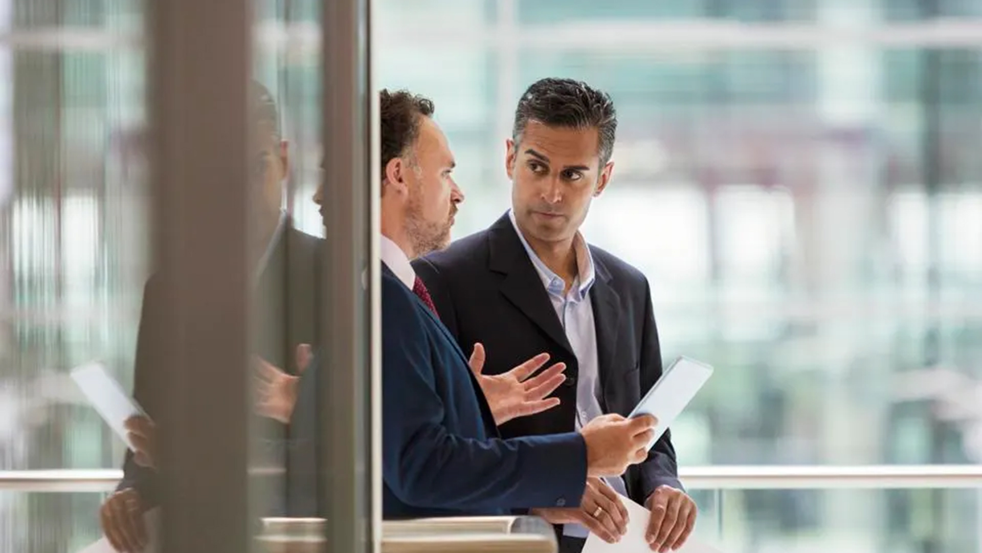 オフィスビルで立ち話をしている二人のビジネスマン