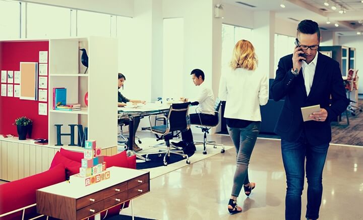 man walking with phone in office