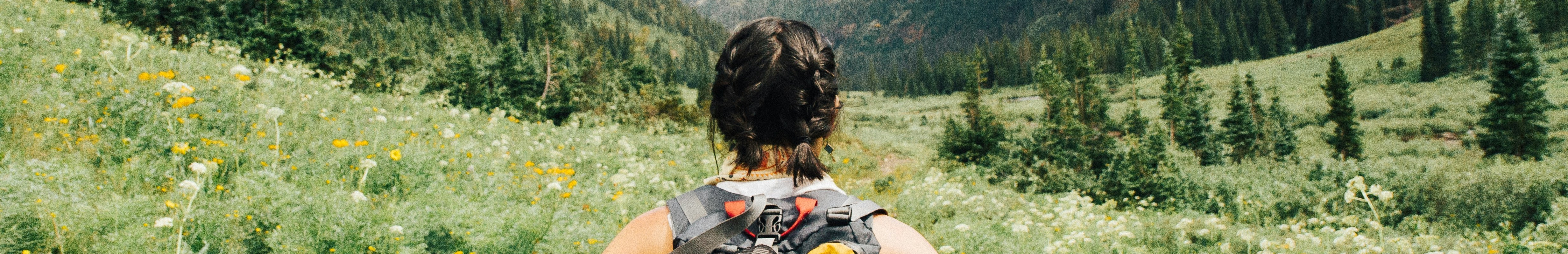 Femme portant un sac à dos lors d'une randonnée en plein air.