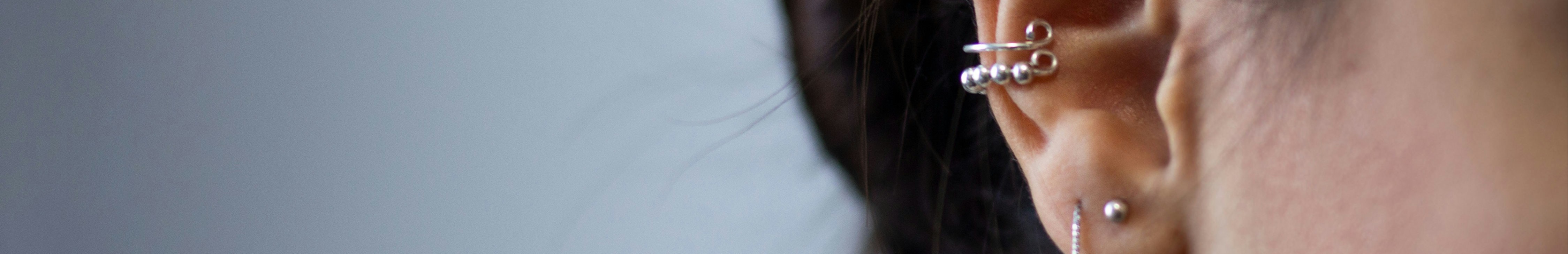 Femme portant des boucles d'oreilles argentées.