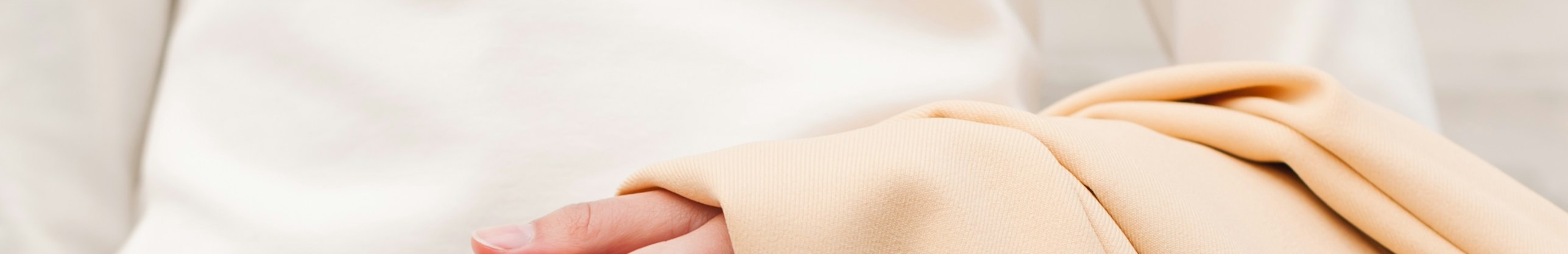 Une femme en robe blanche portant une veste beige.