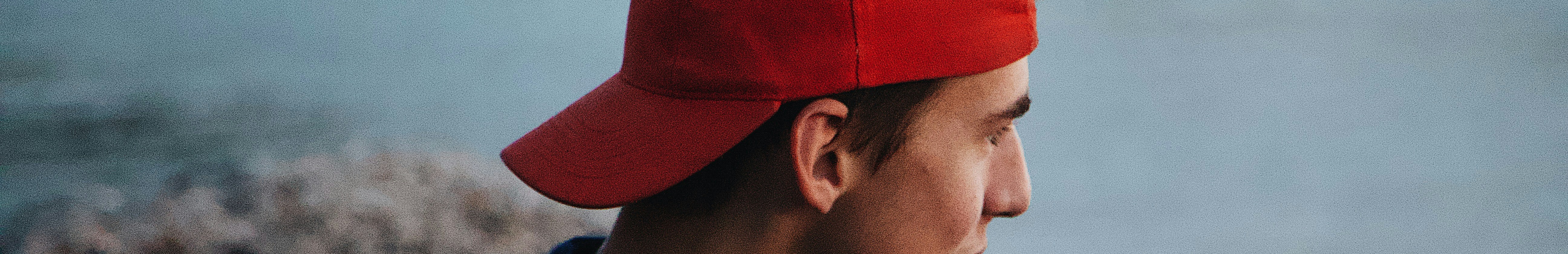 Jeune homme portant une casquette rouge à l'envers.