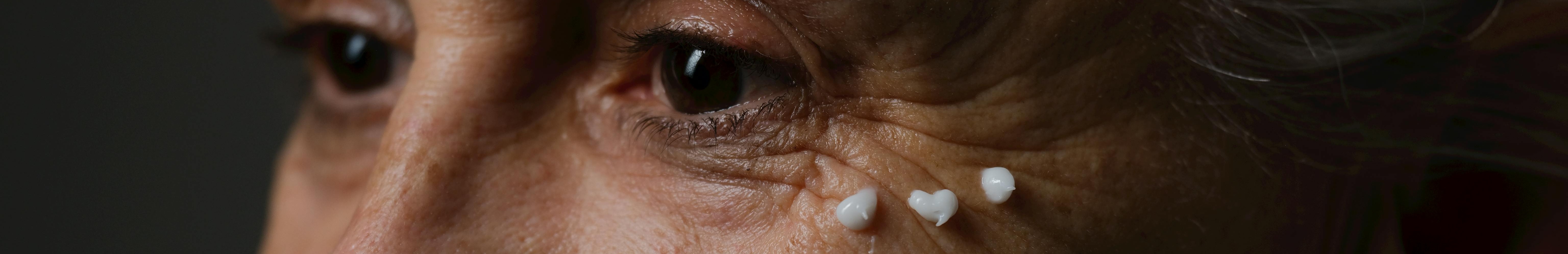 Femme âgée avec de la crème sur le visage.