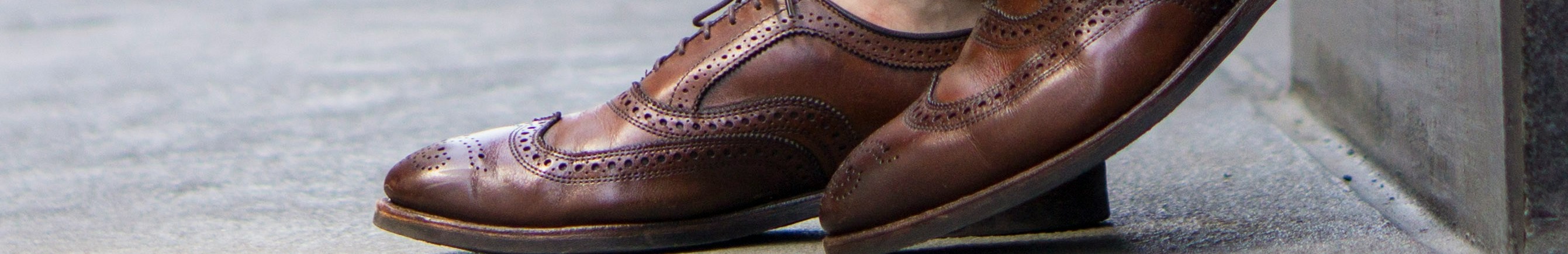 Personne portant des chaussures en cuir marron avec un pantalon beige.