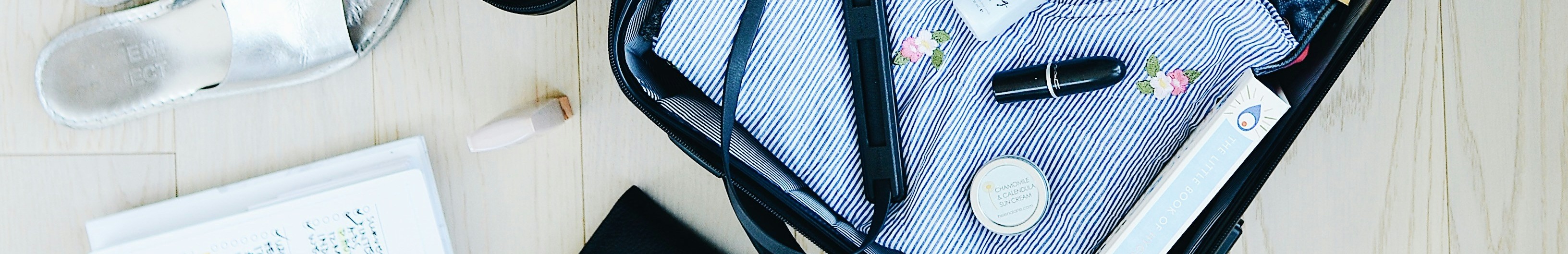 Valise ouverte avec les essentiels de voyage.