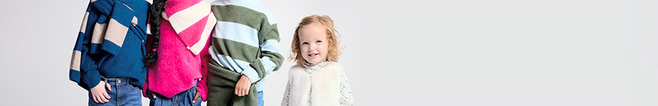 Quatre enfants habillées en vêtements d'hiver Okaïdi.