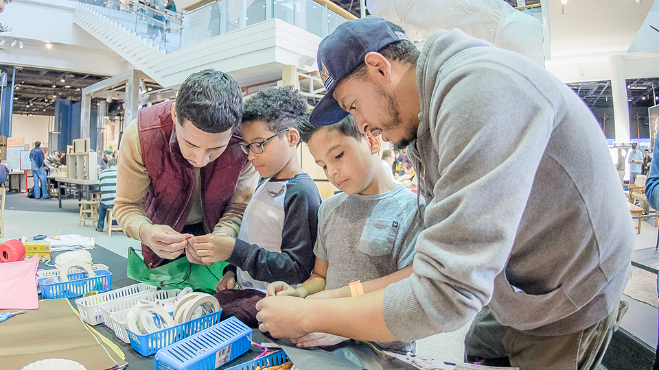 Image of two adults with two boys doing science experiments