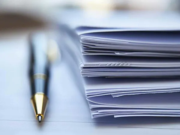 Report documents on table with a pen