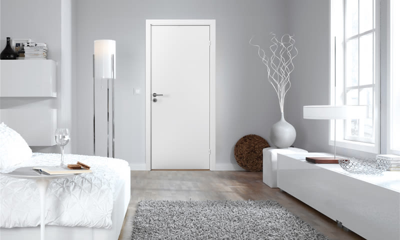 Moderne minimalistisk rom med hvit dør, sofa med brettbord, grå vegg, vindu og vase