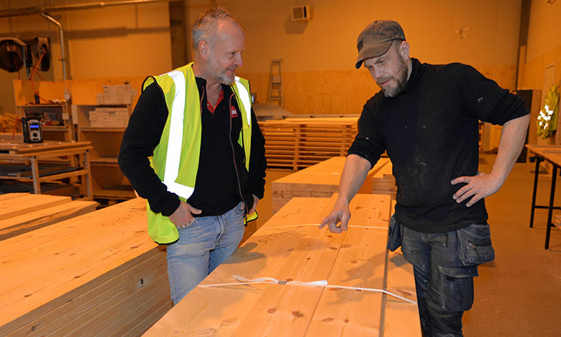 ansatt fra byggmakker og arbeidsleder diskuterer materialer