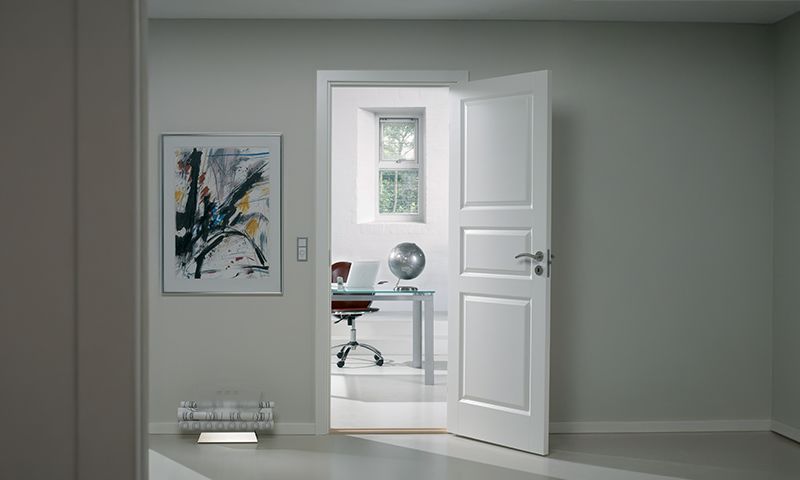 Hvit innerdør inn til kontor på lys vegg
