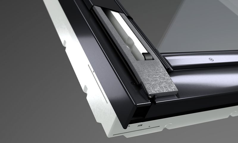 Nærbilde av sort takvindu-hjørne med glass, grått isolasjonsskum og hvitt monteringsfeste