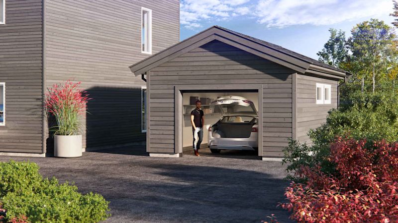 Grå tregarasje ved moderne hus med åpen port, sølvfarget elbil, person, rødt og grønt buskas.