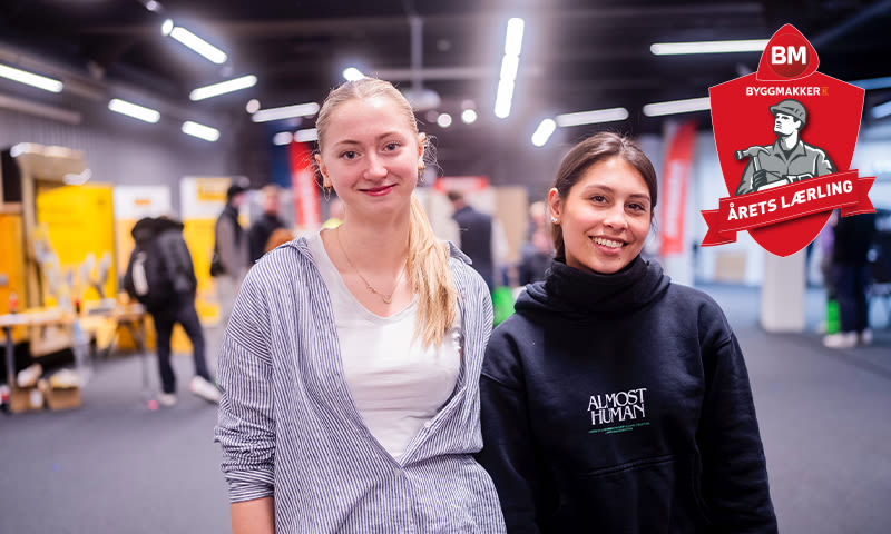 To unge ved stand i lys messesal, gule stands i bakgrunnen og rødt «Årets lærling»-emblem.
