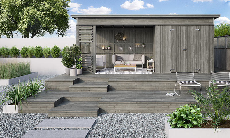 Åpen grå hagebod med treterrasse, sofa, stoler, grønne planter og blå himmel
