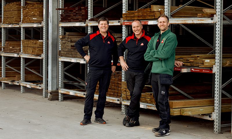 tre menn som står ved terrassebord på reoler