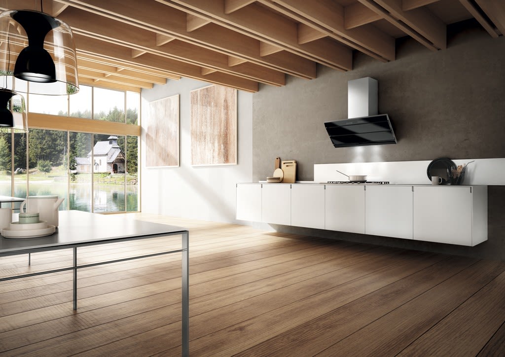 Moderne kjøkken med hvite skap, svart ventilator, eikegulv, vinduer mot innsjø og hytte.