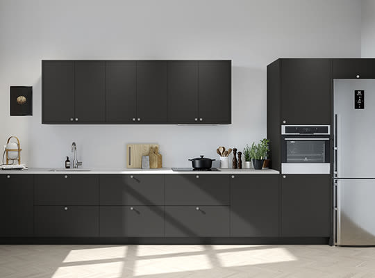 Minimalist kjøkken med mørkegrå skap, hvit benkeplate, stålkjøleskap og innebygd ovn.