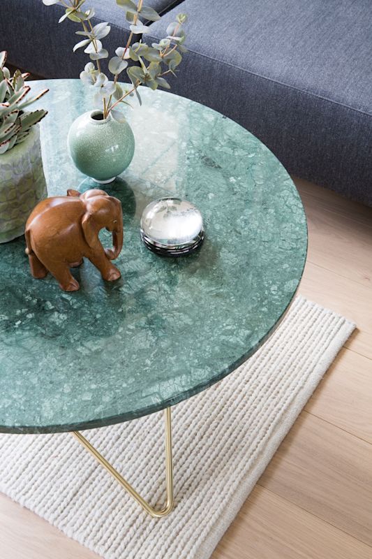 Sofabord av grønn marmor med gullben, grønn vase med eukalyptus, sukkulent, treelefant og sølvboks