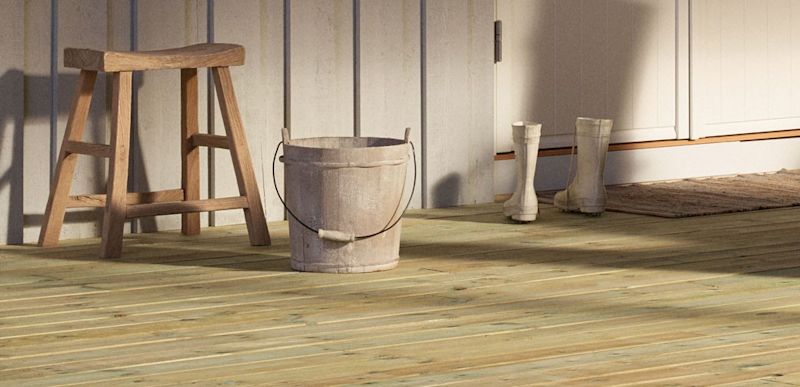 Utegang med lys trestol, bøtte og hvite gummistøvler ved hvit paneldør i sollys