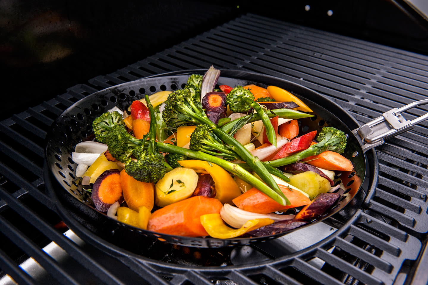 Grillpanne med fargerike grønnsaker på grillrist: brokkoli, gulrøtter, paprika og løk