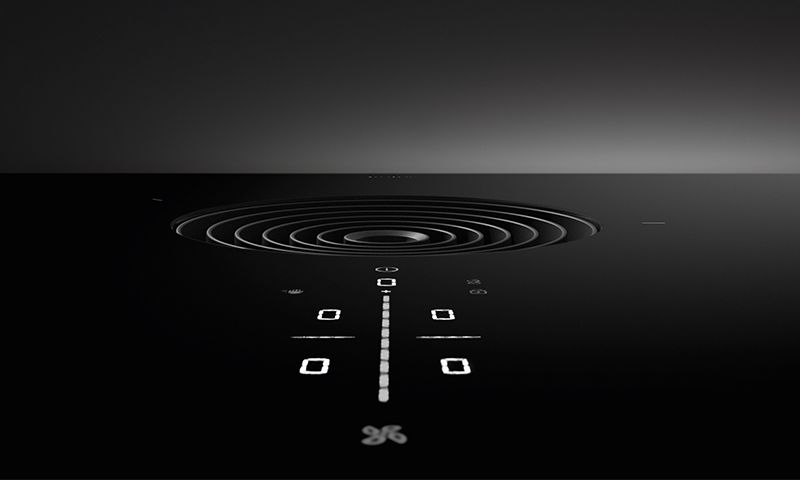 Svart glaskeramisk koketopp med integrert sirkulær uttrekksventil og lyse LED-symboler.