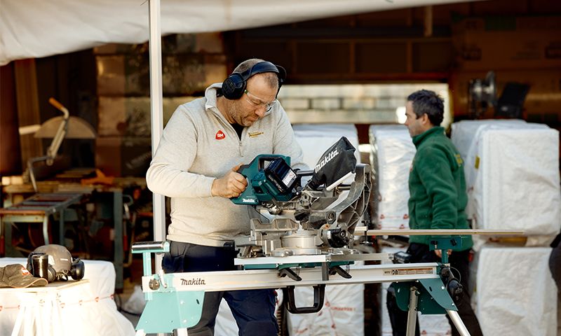mann på byggeplass som bruker en kapp-og gjærsag