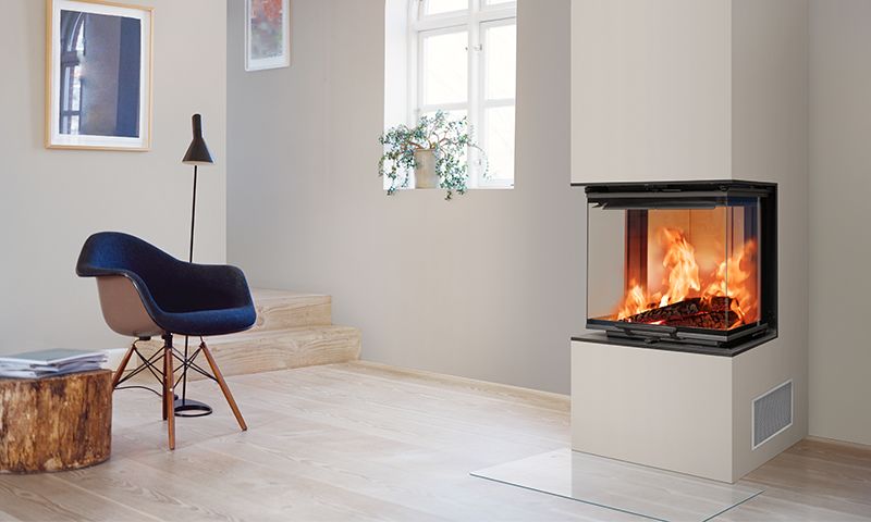 Moderne stue med glasspeis, svart lenestol, trestammebord, lys parkett og vindusplante.