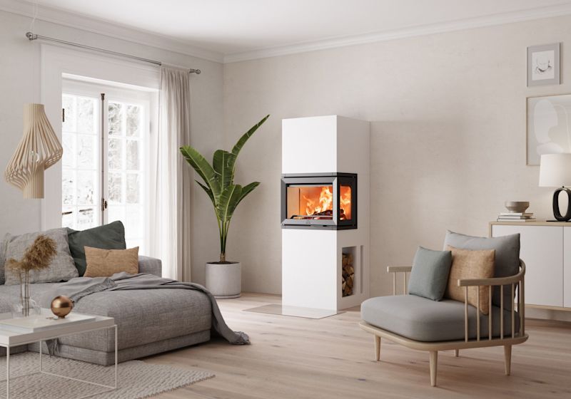 Lyst stueinteriør med grå sofa, grønn plante og moderne hvit vedovn med ild