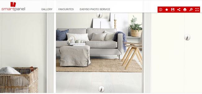 Lyst nordisk rom med grå sofa, grå puff, jute-teppe, trebord og oppbevaringskurver.