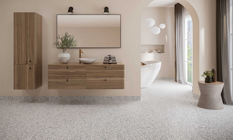 Lyst baderom med beige vegger, treinnredning, spraglet gulv og buet åpning mot badekar