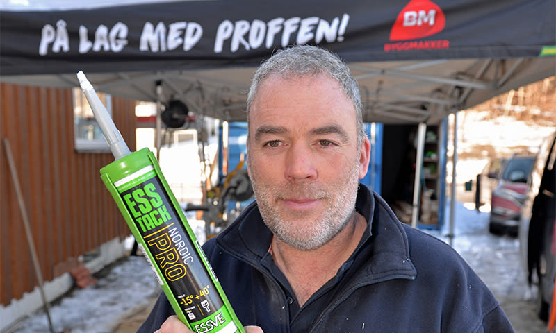 Arbeider holder grønn Ess Tack Nordic Pro fugepistol under telt med «På lag med proffen!»-logo.