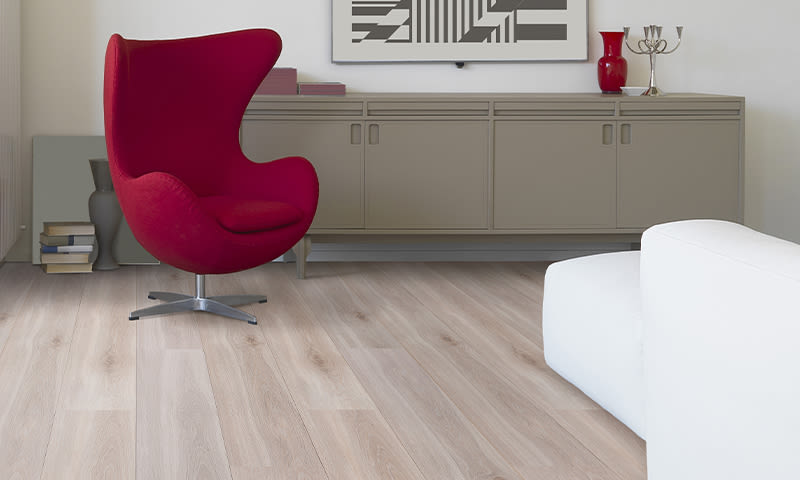 Moderne stue med rød Egg-stol, beige skjenk, hvit sofa og lyst tregulv