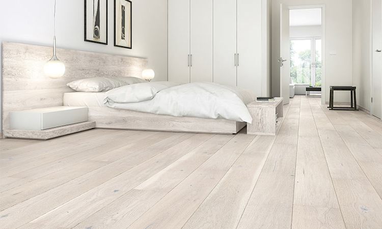 Lyst minimalistisk soverom med hvit dobbeltseng, hengende lamper, lyst tre og garderobe.