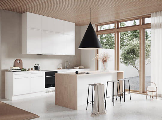 Kjøkken med lys treøy, hvite skap, svart pendel, trespanel i taket og store vinduer.