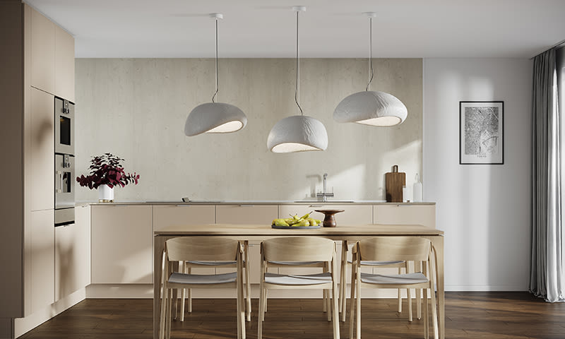 Beige minimalistisk kjøkken med trebord, seks lyse stoler, tre hvite pendellamper og frukt