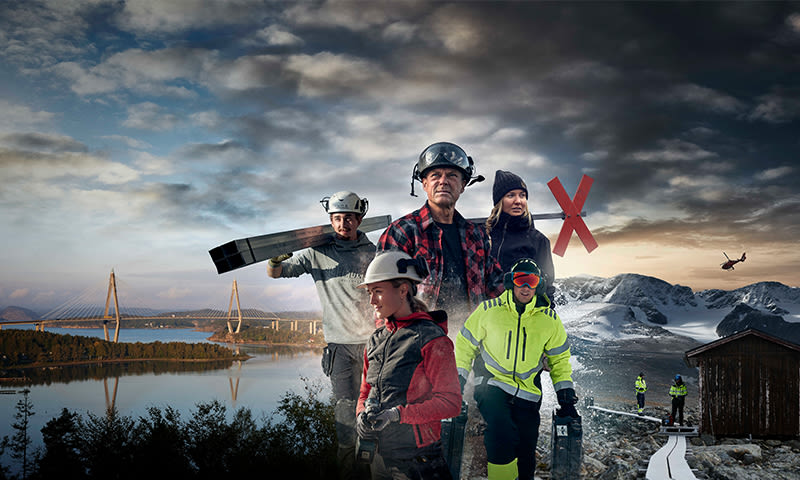 Fem arbeidere i verneklær foran fjord med bro, snødekte fjell, hytte og helikopter