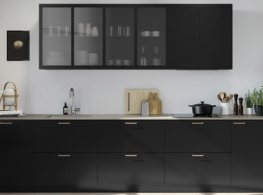 Moderne kjøkken med matte sorte skap, ribbet glass, lys benkeplate, vask, skjærebrett og potteplante