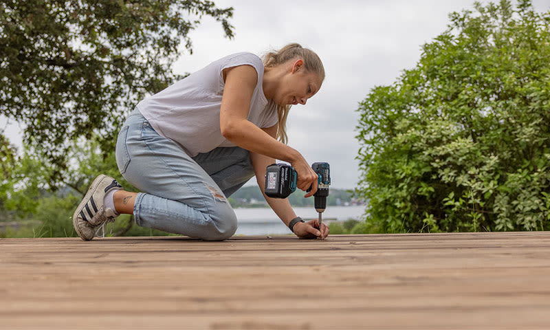 kvinne bygge terrasse med drill